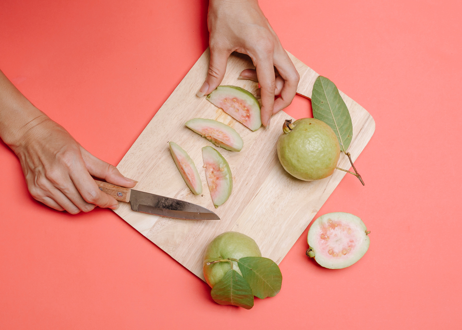Crop person cutting guava on board